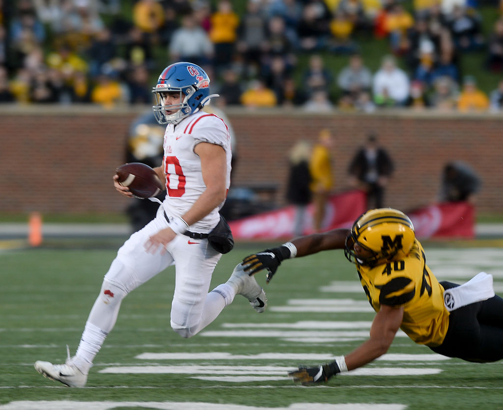 Ole Miss quarterback John Rhys Plumlee evades the grasp of Missouri linebacker Cameron Wilkins